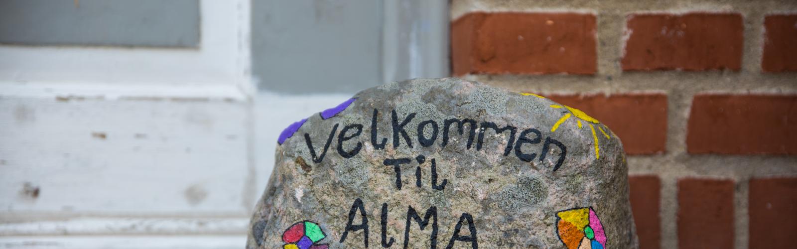 Sten med teksten "Velkommen til Alma"