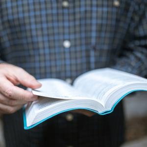 Mand der holder en bibel i hånden
